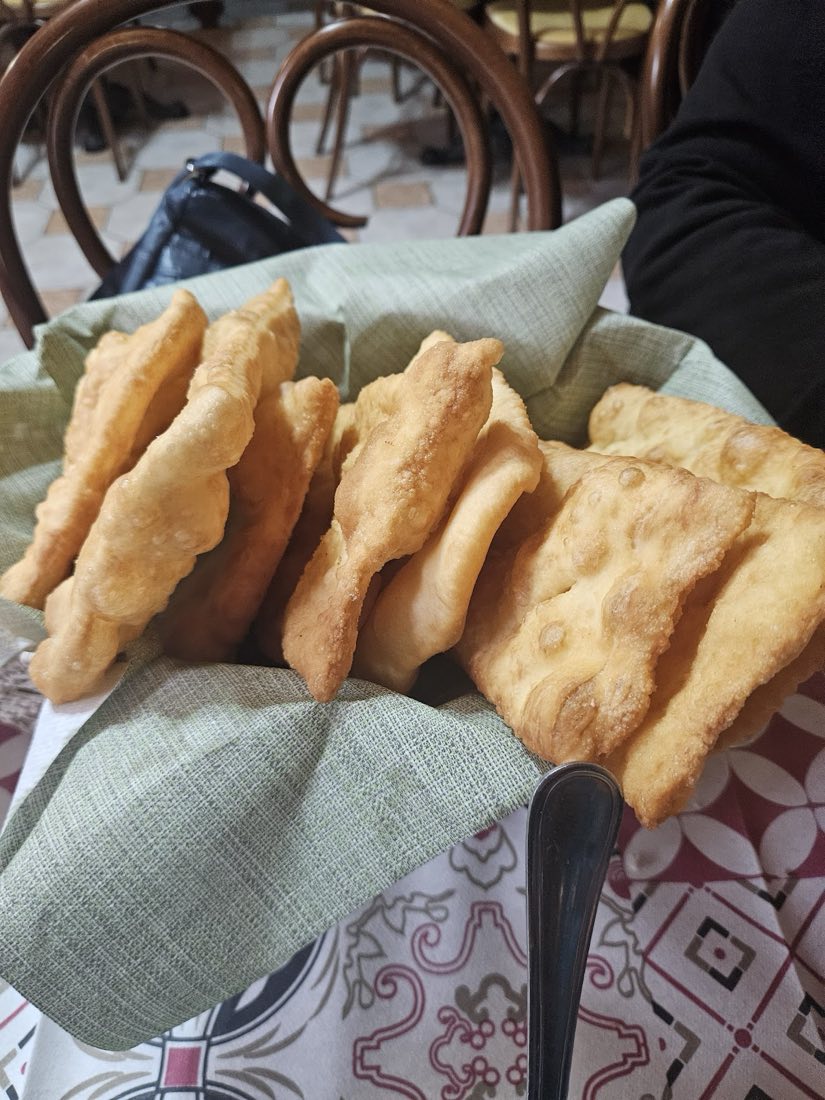 Crescentine fritte e calde nel cestino, avvolte in un tovagliolo verde